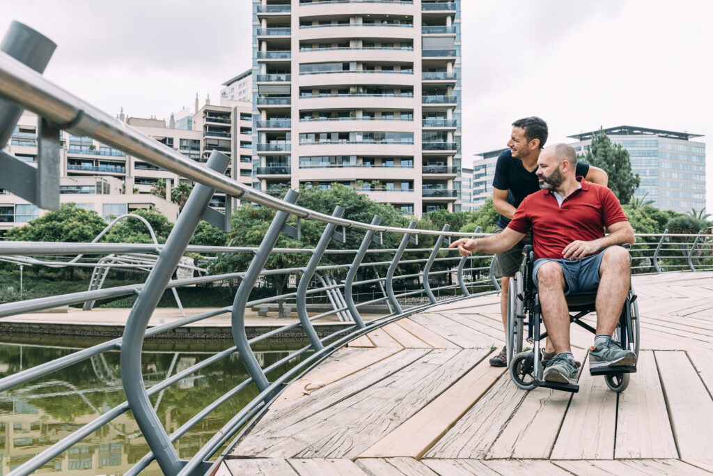 man in a wheel chair talking to his friend