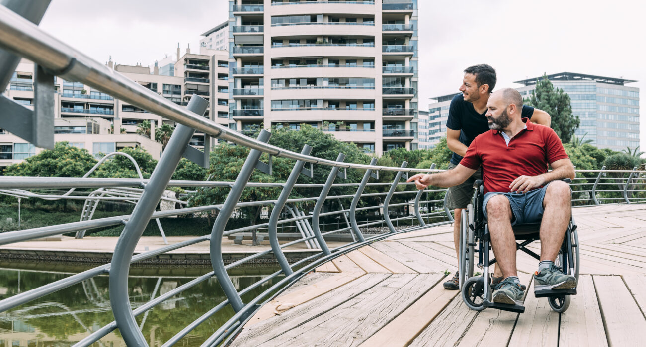 man in a wheel chair talking to his friend