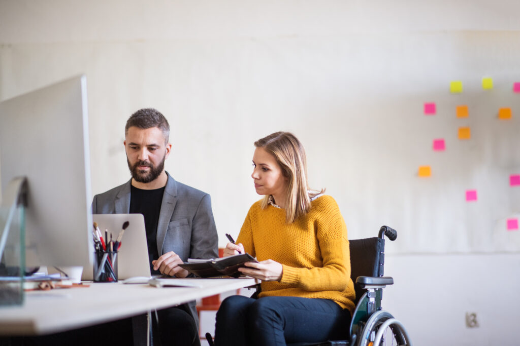 staff and participant sitting in a wheel chair having conversation